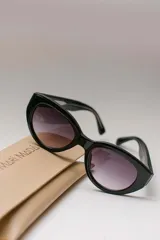 Lentes de sol ovalados con montura de acetato color naranja y lentes marrones degradados. Ofrecen protección UVA/UVB.