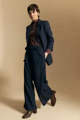 Pantalón de vestir negro de corte ancho y tiro alto, con silueta fluida y diseño minimalista.