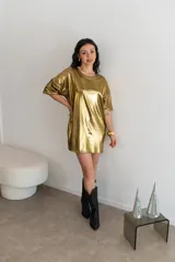 Remerón de manga corta, corte oversize, color dorado metálico con textura brillante.