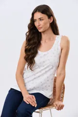 Musculosa de algodón blanca con pequeño estampado floral y volados en los tirantes, de corte clásico.