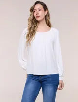 Blusa de modal y elastano color blanco, de silueta holgada, escote redondo amplio con elástico interno fruncido y mangas largas fluidas con puños ajustados.