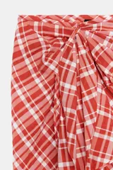 Falda midi de tiro medio ZARA WOMAN COLLECTION confeccionada en hilatura con algodón, con estampado de cuadros en tonos rojos y blancos. Presenta detalle de pliegue con lazadas en el delantero y bajo recto con abertura. Cierre con cremallera oculta en costura.
