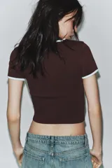 Camiseta negra de manga corta y cuello redondo, con vivos a contraste en el cuello y las mangas.