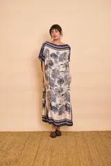 Vestido midi amarillo y blanco con estampado de paisajes y detalles de rayas en el cuello y el dobladillo, de corte holgado, mangas cortas y lazo ajustable en la cintura.