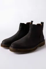 Bota tipo Chelsea de cuero color marrón oscuro, con paneles laterales elásticos y suela de goma con efecto madera.