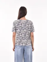 Remera blanca con estampado animal print en negro, de corte recto y mangas cortas.