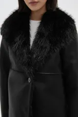 Chaqueta de eco-cuero negro con interior y cuello de piel sintética, diseño holgado, manga larga y cierre frontal con un botón.