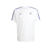 Camiseta de fútbol Adidas del Real Madrid, inspirada en los modelos de los años 80. Diseño blanco con detalles en violeta, logo de Adidas y escudo del club bordados. Corte holgado.