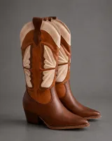 Botas texanas de caña alta confeccionadas en cuero en tonos marrón y tostado, con diseño geométrico pespunteado, puntera fina y taco cuadrado.
