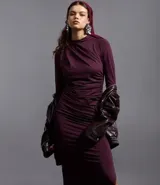 Vestido midi de manga larga en color bordó, con diseño ajustado al cuerpo, cuello redondo y detalle de pliegues asimétricos en uno de los hombros. Presenta una abertura lateral en el ruedo.