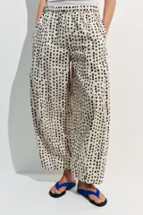 Pantalón estilo pijama de tiro medio, confeccionado 100% en algodón. Cuenta con cintura elástica, bolsillos laterales ocultos en la costura y diseño de corte barrel con estampado de lunares.
