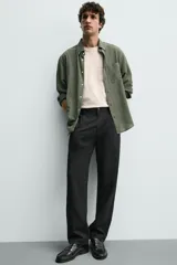 Pantalón de corte recto confeccionado en tejido elástico, con cintura elástica, pliegues frontales, bolsillos laterales y bolsillos traseros de vivo con botón.