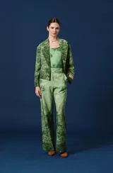 Pantalón de corte recto y tiro alto, de color beige con un estampado paisajístico de árboles y naturaleza en tonos marrones y grises. Cuenta con trabillas en la cintura y cierre frontal oculto.