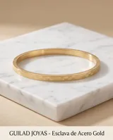Esclava rígida de acero con baño de oro, caracterizada por un diseño geométrico grabado en toda su superficie.