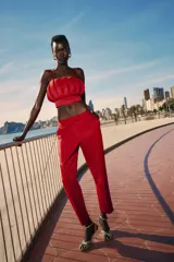 Pantalón capri de vestir color rojo, de corte slim, tiro alto, con pinzas delanteras, bolsillos laterales y falsos bolsillos traseros.