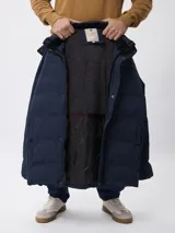Campera de nylon acolchada en color azul marino, con cierre frontal y botones a presión, bolsillos laterales y capucha desmontable.