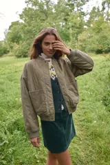 Campera bomber acolchada en tejido guateado color verde militar. Modelo oversized con cuello corto acanalado, hombros caídos, cierre con botones a presión y bolsillos delanteros de parche. Puños y bajo acanalado. Forrada.