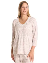 Conjunto de pijama compuesto por una remera de mangas largas con escote redondo y bolsillo frontal, y un pantalón largo con cintura elástica. Ambas piezas presentan un estampado floral y detalles de apliques de crochet en el cuello y el bolsillo.