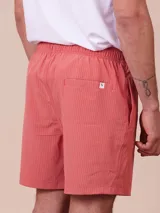 Short de baño color ladrillo con rayas verticales en relieve, cintura elástica con cordón ajustable y bolsillos laterales.