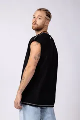 Musculosa oversize de algodón estilo sudadera, color crudo, con costuras visibles en contraste en color negro que recorren el centro verticalmente y enmarcan el cuello y el ruedo.