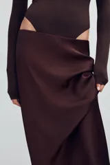 Falda midi de tiro alto y cintura elástica, confeccionada en tejido satinado de color negro.