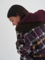 Buzo canguro oversize con capucha y cuello alto, confeccionado con paños de lana estampados.