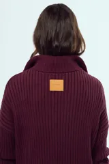 Sweater de tejido de punto color bordó, con cuello alto, cierre frontal parcial y mangas largas.