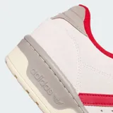 Championes Adidas Rivalry Low de cuero y gamuza color blanco hueso con detalles en rojo y gris.