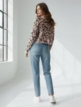 Buzo de lana con diseño de animal print en tonos rosado y marrón oscuro. Es de corte crop, manga larga amplia y cuello redondo.