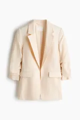 Blazer entallado color beige en mezcla de viscosa, con hombreras, solapas de muesca, bolsillos delanteros con solapa y mangas tres cuartos fruncidas. Diseño sin cierre y con forro interior.