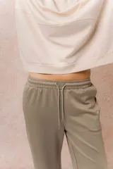 Pantalón gris melange de calce relajado y pierna amplia, con cintura elastizada y cordón regulable. Cuenta con bolsillos laterales y tejido de tacto suave.