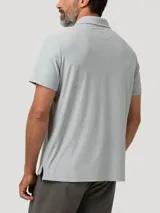 Chomba gris melange de manga corta con cuello polo, cierre frontal de tres botones y un bolsillo aplicado en el pecho.