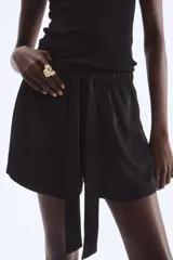 Short negro de sarga con cintura elastizada y cordón para ajustar. De corte holgado y tiro alto, con bolsillos laterales.