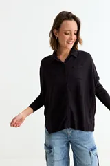 Cardigan negro de manga larga, con cuello camisero, botones frontales y un bolsillo en el pecho.
