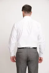 Camisa de vestir blanca de manga larga, con cuello clásico y cierre frontal de botones. Presenta un corte entallado que se adapta a la silueta.