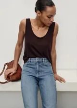 Jeans tipo mom-fit de tiro alto con diseño de cinco bolsillos, trabillas y cierre frontal con cremallera y botón.