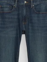 Jean de corte skinny, color azul oscuro con efecto de lavado localizado, confeccionado en denim con tecnología Softmax para mayor flexibilidad y comodidad.