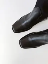 Botas texanas de cuero negro con caña media, puntera cuadrada y tacón bloque.