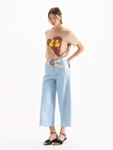 Remera gris oscuro con efecto acid wash, corte clásico, mangas cortas y cuello redondo. Cuenta con una estampa frontal de un corazón rojo con dos patitos amarillos besándose.
