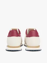 Zapatillas runner Tommy Jeans Eva de estilo urbano, confeccionadas en una combinación de cuero blanco, textil y material sintético. Presentan detalles en color bordó en el talón y el interior, entresuela con franja marrón y suela dentada azul. Cuentan con el logo de Tommy Jeans bordado en el lateral.
