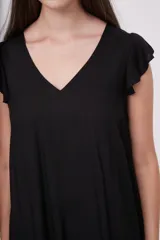 Vestido corto negro con escote en V y mangas cortas con volados. Tiene corte suelto y un volante en el ruedo.