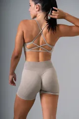 Top deportivo color beige con breteles finos cruzados en la espalda.