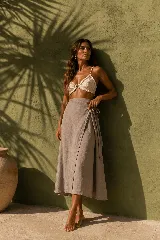 Falda larga cruzada de lino color gris, con lazo lateral para ajustar en la cintura, diseño fluido y corte evasé.