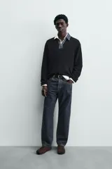 Polo de punto color azul marino, de calce relajado y manga larga. Presenta un cuello solapa de tejido denim en contraste con una abertura frontal en forma de V.