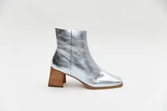 Botas plateadas de cuero con caña media, cierre lateral con cremallera, punta cuadrada y tacón geométrico de madera.