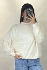 Buzo de cuello redondo, corte oversize, con mangas largas y puños elásticos.