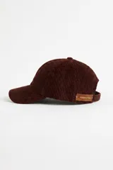 Gorro tipo cap de pana en color bordó, con detalle de etiqueta de cuero en el lateral.
