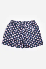 Short de baño celeste con estampado de hojas pequeñas en tonos verdes y blancos. Cuenta con cintura elástica con cordón ajustable, bolsillos laterales y un parche circular con logo en la parte inferior.