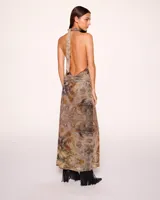 Vestido largo con estampado abstracto en tonos tierra, escote halter y choker al cuello. Presenta abertura frontal con volantes y detalle de hebilla con logo en la cintura.