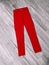 Pantalón cargo rojo de tela bengalina, con bolsillos laterales con solapa y tobillos ajustados.